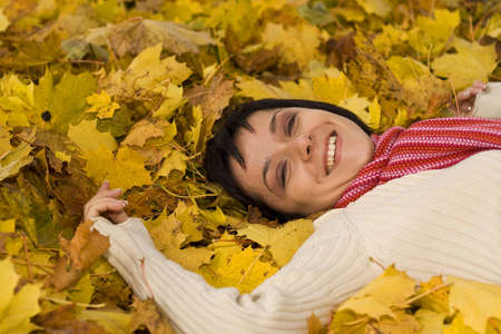 Young pretty woman on the autumn leaf の写真素材