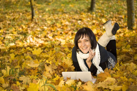 beautiful sexy woman portrait working on laptop computer in natural autumn outdoors の写真素材