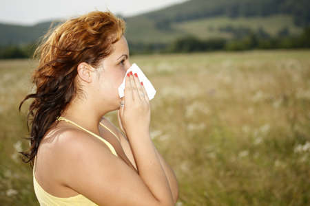 brunette woman having a pollen allergy in the natureの写真素材