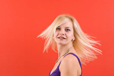 Portrait of young dancing girl in red backgroundの写真素材