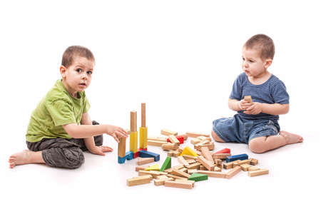 Boys playing whit blocks isolated on whiteの写真素材