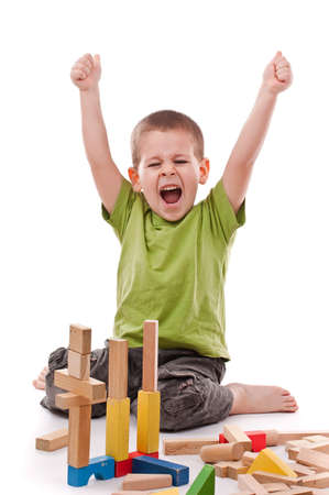 little boy playing with colorful blocks, isolated on white backgroundの写真素材