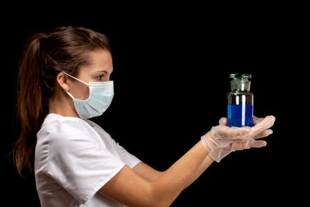 Portrait of young scientist holding medical bottle with blue liquidの写真素材