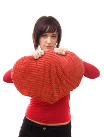 Angry woman tearing a heart-shaped pillowの写真素材