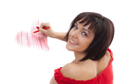 Beautiful young woman with wax crayon lying on floor and drawing heart-shapeの写真素材