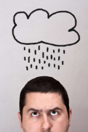 Male with rain cloud  over his headの写真素材