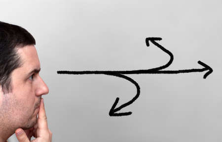 Young male thinking with arrows coming from head - decisions and choices conceptの写真素材