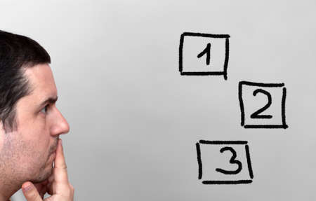 Young male thinking  - decisions and choices conceptの写真素材