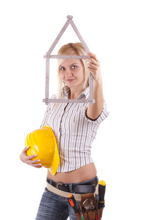 Sexy blonde engineer woman with a folding rule in her hand in form of houseの写真素材