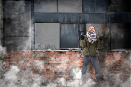 Terrorist with rifle, grunge buildings in backgroundの写真素材