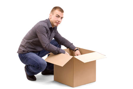 young men reaching something inside a cardboard box 