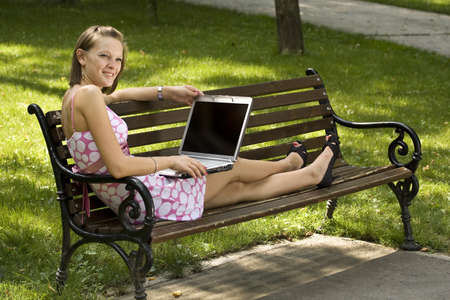A beautiful college student working on her laptop on campusの写真素材