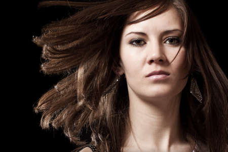 Young brunette woman portrait in black の写真素材