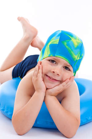 Funny little boy playing with blue life ring in swim caps, isolated in whiteの写真素材