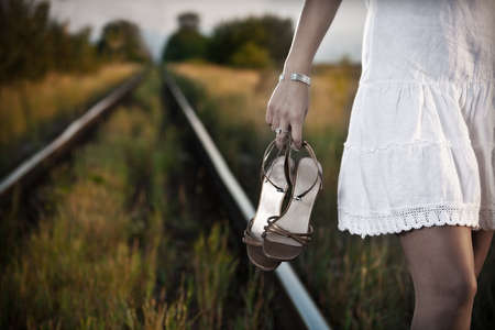 picture of young woman hand with shoes on the railway の写真素材