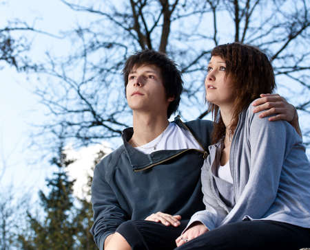 Young couple in the park, blue sky in backgroundの写真素材