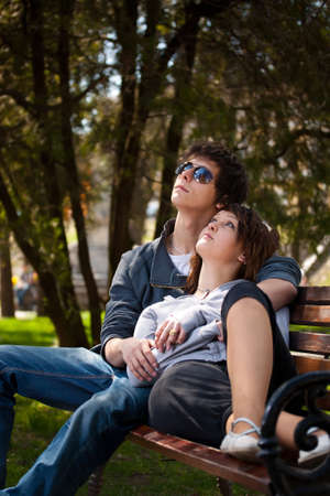 Attractive couple sitting on bench in the park の写真素材