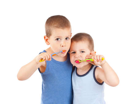 Young boys brushing his teeth with toothbrush, isolated in whiteの写真素材