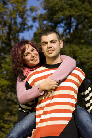 Portrait of love couple embracing outdoor in park looking happy の写真素材
