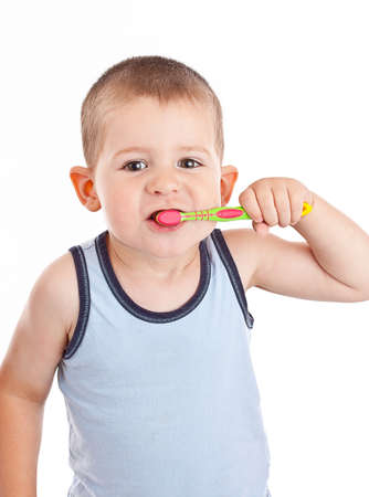 Young boy brushing his teeth with toothbrush, isolated in white