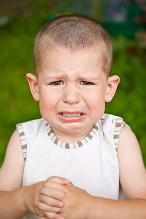 Closeup of a crying boy, outdoor shot