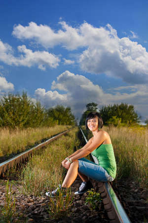 happy girl sitting on the railroad の写真素材