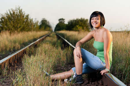 A girl sitting on the railroad の写真素材