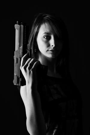 Sexy woman with Gun, isolated on black backgroundの写真素材