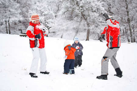 Young family throwing snowballs on winter vacationの写真素材