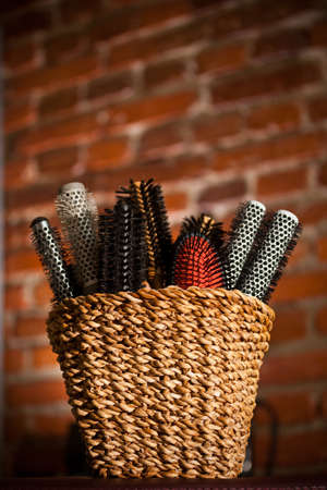 Basket with round hair brushes, brick wall on backgroundの写真素材