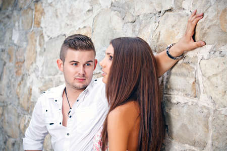 Attractive young couple posing in a stone wallの写真素材