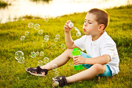 Little boy blowing soap bubbles の写真素材