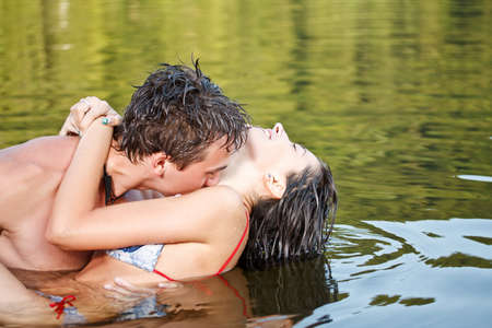 Young beautiful couple are kissing in the water の写真素材