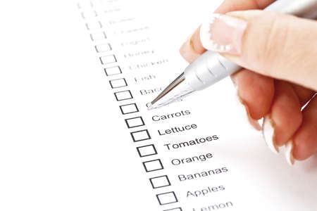 Woman hand checking a shopping list 