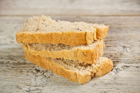 Closeup of sliced bread on old wood table