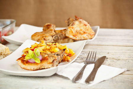 Grilled pork loin chops served with potatoの写真素材