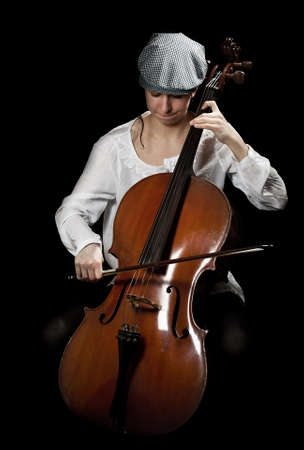 girl playing cello, in black backgroundの写真素材