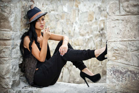 Young woman smoking in a ruined buildingの写真素材