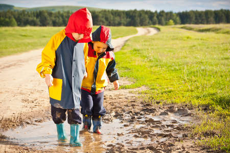 Boys walking in a mud puddle の写真素材