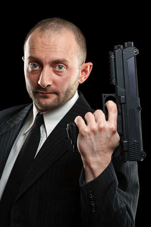 Portrait of a handsome man holding a gun. Studio shot. 