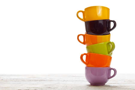 Tower of color cups on old wood tableの写真素材