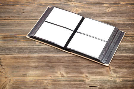 Open photo album book on old wooden table 