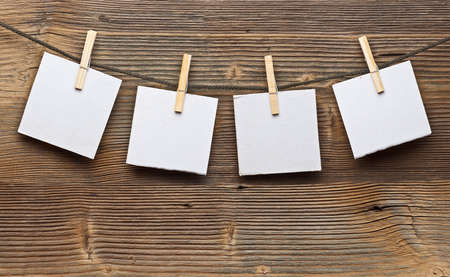 Paper card and clothes peg on a wooden background