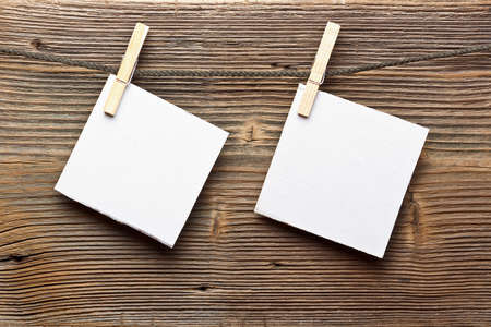 Notes and a clothes pegs on wood background 