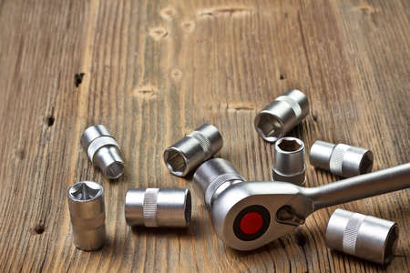 Socket wrench on wood background