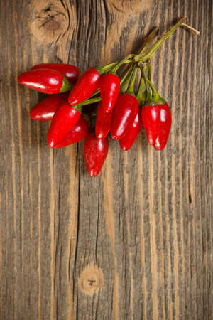Red hot chili peppers on old wooden table の写真素材