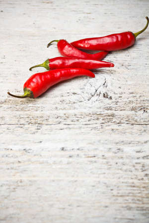 Red hot chili peppers on old wooden table の写真素材