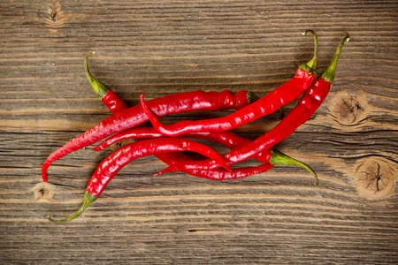 Red hot chilli peppers on wood background