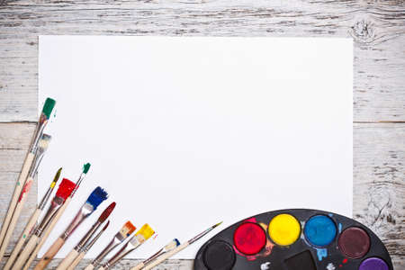 Used watercolor paints set with brushes and paper sheet の写真素材