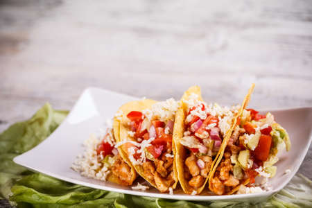 Tacos with lettuce, cheese and tomato の写真素材